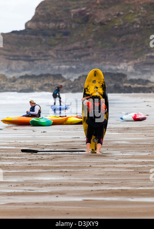 A person repairs a kayak on Black Rock beach, Widemouth Bay, nr Bude, Cornwall Stock Photo