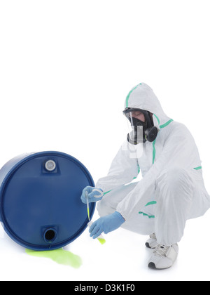 Man wearing protective suit and respirator sampling dangerous chemical ...