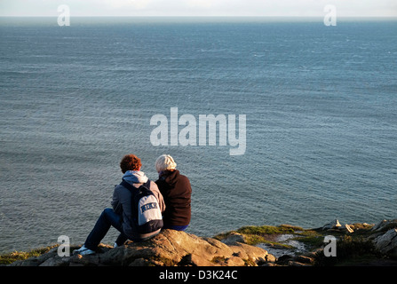 A couple take in the Atmospheric view from Howth Hill, Fingal Dublin Ireland Stock Photo