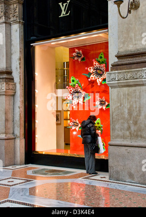 Woman looking in Louis Vuitton boutique window Galleria Vittorio Emanuele II Milan Lombardy Italy Europe Stock Photo