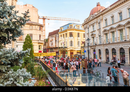 Tourists stroll down a crowded cobblestone street of old historical center Lipscani on September 13, 2012 in Bucharest, Romania. Stock Photo