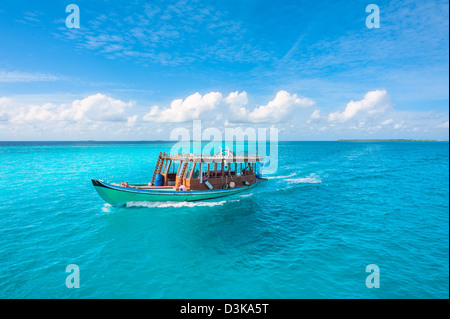 View from the bow of Maldivian wooden dhoni boat on tropical island and turquoise ocean Stock Photo