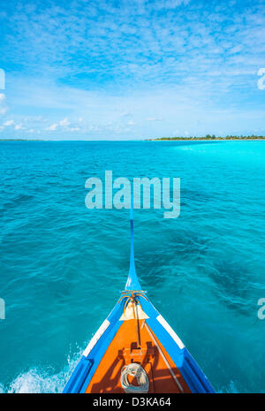 View from the bow of Maldivian wooden dhoni boat on tropical island and turquoise ocean Stock Photo