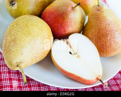 Ripe pear on white background. The cultivation of the pear in cool temperate climates extends to the remotest antiquity, and there is evidence of its use as a food since prehistoric times. Stock Photo