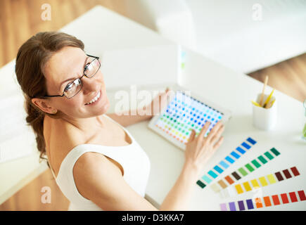 Happy female designer looking at camera at workplace Stock Photo
