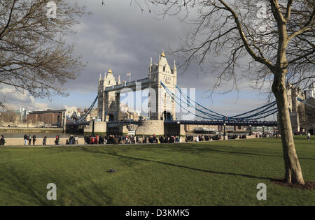 Tourists strolling along the Queens Walk beside Tower Bridge on a sunny winters day London England UK GB Stock Photo