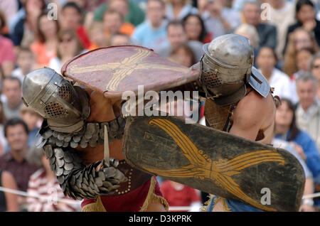 (dpa) - Two actors, dressed as gladiators, stage a fight at the amphitheatre in Trier, Germany, 13 August 2005. At the Roman spectacle 'bread and games' visitors relive what life was like in Roman times. Trier, then named Augusta Treverorum, was founded by the Romans in the year 16 before Christ. 301 years later, Trier became Roman imperial residence. Photo: Harald Tittel Stock Photo