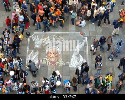 (dpa) - Pilgrims of the 20th World Youth Day surround a large drawing of Pope Benedict XVI, which is the creation of a street painter, on the cathedral square in Cologne, Germany, 15 August 2005. Catholic youths from around the world are going to meet the first German pope in 500 years at the World Youth Day which runs from 16 August to 21 August 2005. 400,000 young people from aro Stock Photo