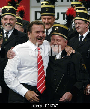 (dpa) - German Chancellor Gerhard Schroeder smiles as he stands amidst a miners' choir during the concluding session of the SPD's special party conference in Berlin, Wednesday, 31 August 2005. With the party conference, the Social Democratic Party (SPD) is entering the final stage of the election campaign three weeks ahead of the general elections for the German Bundestag parliamen Stock Photo