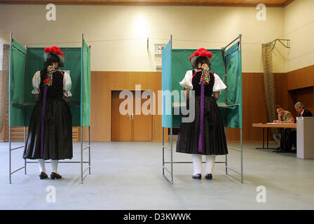 (dpa) - Dressed in their traditional Black Forest costume and wearing 'Bollenhats' Bettina Moser (L) and Susanne Kienzle (r) cast their ballots in Wolfach-Kirnbach; Germany, Sunday 18 September 2005. Around 62 million eligible voters will decide on a new Bundestag in Germany. Photo: P atrick Seeger Stock Photo
