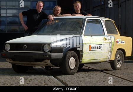(dpa) - Car mechanics Ulrich Kock, Helge Thomsen and Patrick Nix (L-R) present the 'Gobbi' in Hamburg, Germany, 22 September 2005. The 'Gobbi' is a combined construction of a VW Golf and German Democratic Republic (GDR) product 'Trabant'. To celebrate the 15th anniversary of the German Unity the three mechanics also painted the 'Gobbi' in the German national flag colours black, red Stock Photo