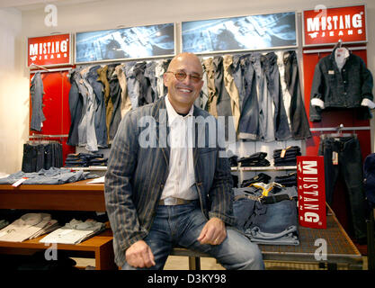 (dpa file) - Heiner Sefranek, CEO of clothing retailer Mustang, sits smiling between shelves with clothing of the denim brand Mustang at the company's headquarter in Kuenzelsau, Germany, 06 April 2005. Photo: Harry Melchert Stock Photo