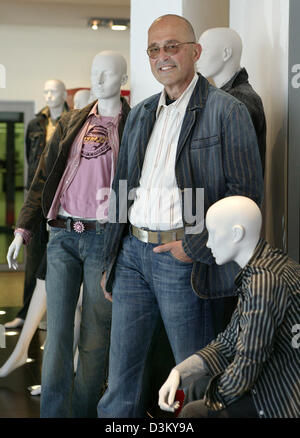 (dpa file) - Heiner Sefranek, CEO of clothing retailer Mustang, sits smiling between display dummies with clothing of the denim brand Mustang at the company's headquarter in Kuenzelsau, Germany, 06 April 2005. Photo: Harry Melchert Stock Photo