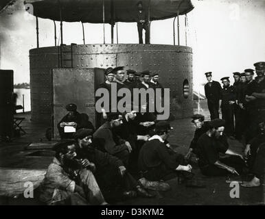 Undated photograph showing the crew of ironclad warship the USS Monitor relaxing just outside of its turret. The Brooklyn-built Monitor made nautical history after being designed and assembled in 118 days, and then commissioned, Feb. 25, 1862. Monitor fought in the Battle of Hampton Roads March 9, 1862 against CSS Virginia. It was the first battle between two ironclads and signaled the end of the era of wooden ships. Stock Photo