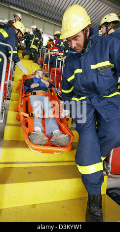 (dpa) - Fire fighters rescue one of the supernumeraries in special stretcher during an emergency practice at the Fritz Walter stadium in Kaiserslautern, Germany, Saturday 08 October 2005. Over 800 staff members of police forces, fire brigade and rescue services took part in the practice to prepare for the worst case during the Soccer World Championship in 2006. Photo: Ronald Wittek Stock Photo