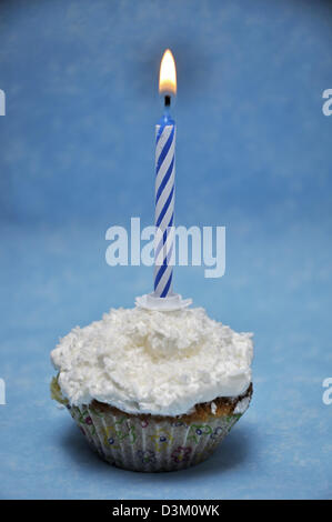 Vanilla cupcake with lit candle on top Stock Photo