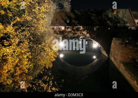 (dpa) - The picture shows the nocturnal view on a part of the Old Town wall at the Schleyer tower of the Haller gate with the Pegnitz river running under it in Nuremberg, Germany, 26 October 2005. Photo: Daniel Karmann Stock Photo