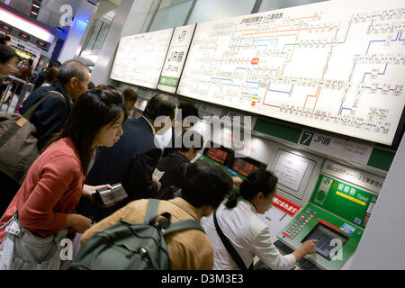 (dpa files) - Commuters queue in front of ticket vending machines at a  suburban railway service station in Tokyo, Japan, 10 October 2005. Tokyo has a very efficient network of public metropolitan and suburban commuter systems. Photo: Gero Breloer Stock Photo