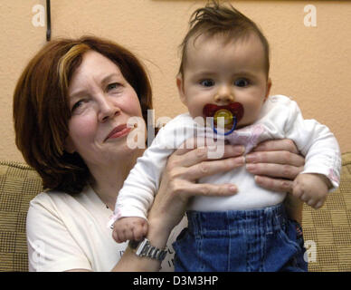 (dpa) - 55-year old mother Annegret Raunigk holds her daughter Lelia in her hands at her house in Berlin, Thursday, 03 November 2005. Born in summer 2005 Lelia is the 13th child of Annegret Raunigk who is a working Russian-English language teacher. The baby was conceived and born naturally but, nevertheless, the event came as a surprise to her. Raunigk, who is also the grandmother  Stock Photo