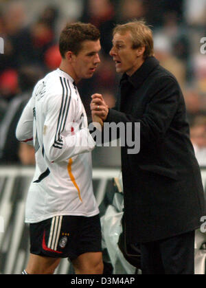 (dpa) - German national head coach Juergen Klinsmann (R) talks to player Lukas Podolski (L) during his substitution in the international test match France vs Germany at Stade de France stadium in Paris, France, 12 November 2005. The game ended in a 0-0 draw. Photo: Oliver Berg