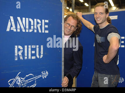 (dpa) - Dutch star violinist Andre Rieu and his son Pierre (24) stand between containers featuring Andre Rieu's name at his warehouse in Maastricht, the Netherlands, 02 November 2005. The 56-year-old musician is about to start the first part of his tour through Canada and the USA, where he will perform at 13 mayor cities. The complete equipment of his crew, which numbers 40 people, Stock Photo