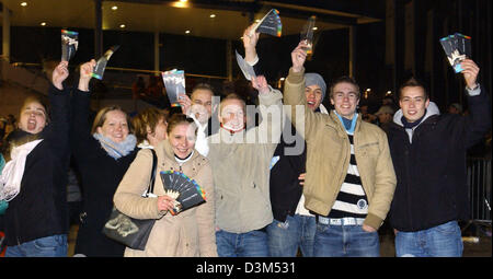 (dpa) - Robbie Williams fans celebrate while holding their tickets for the Robbie Williams concert, which will take place in Hamburg, Germany in the summer of 2006, which they just bought in Hamburg, Germany, just after midnight on 19 November 2005. Several thousand people waited in the cold in front of the AOL arena until the start of the ticket sale to get some of the sought-afte Stock Photo