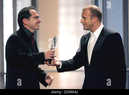 (dpa) - Composer Andrea Guerra (L) receives an award for his 'Hotel Rwanda' soundtrack from German actor Heino Ferch during the 18th European Film Academy Awards ceremony in Berlin, Germany, Saturday, 03 December 2005. The European Film Academy Award was awarded in 17 categories. Photo: Marcus Brandt Stock Photo
