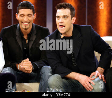 (dpa) - British pop star Robbie Williams (R) sits next to German national soccer player Kevin Kuranyi (L) during the German TV show 'Wetten, dass...?' ('Bet that...?') in Duesseldorf, Germany, 10 December 2005. Numerous international celebrities and German artists were among the guests of Europe's most successful TV show. Photo: Patrik Stollarz Stock Photo