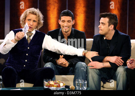 (dpa) - German TV host Thomas Gottschalk (L) talks with British pop star Robbie Williams (R) and German national soccer player Kevin Kuranyi (C) during the German TV show 'Wetten, dass...?' ('Bet that...?') in Duesseldorf, Germany, 10 December 2005. Numerous international celebrities and German artists were among the guests of Europe's most successful TV show. Photo: Patrik Stollar Stock Photo
