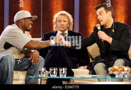 (dpa) - British pop star Robbie Williams (R) shakes hands with US rapper '50 Cent' (L) while German TV host Thomas Gottschalk sits in between them during the German TV show 'Wetten, dass...?' ('Bet that...?') in Duesseldorf, Germany, 10 December 2005. Numerous international celebrities and German artists were among the guests of Europe's most successful TV show. Photo: Patrik Stoll Stock Photo