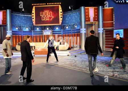 (dpa) - British pop star Robbie Williams (R) wears red socks while playing soccer with US rapper '50 Cent' (L-R), former soccer player Guenter Netzer, host Thomas Gottschalk and German national soccer player Kevin Kuranyi during the German TV show 'Wetten, dass...?' ('Bet that...?') in Duesseldorf, Germany, 10 December 2005. Numerous international celebrities and German artists wer Stock Photo