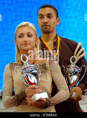 (dpa) - The new figure skating dream couple Ukrainian-born Aljona Savchenko (21) and Robin Szolkovy (R) holds their trophies in their hands after their performance in the freestyle skating competition at the German Championships in Figure Skating in Berlin, Friday, 30 December 2005. With a last minute issued passport six weeks ahead of the Winter Sports Olympics, both skaters manag Stock Photo