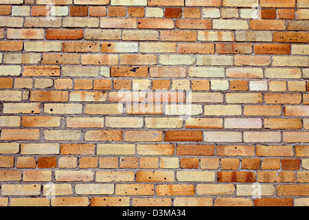 Old weathered yellow brick wall as background Stock Photo