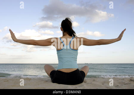 (dpa) - A young woman practices Yoga on the beach of Miami Beach, USA, 23 December 2005. Photo: Gero Breloer