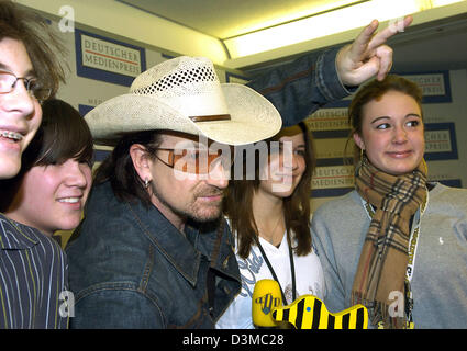 ATTENTION EMBARGO 24 January 2006, 19UHR/ 7PM -- Bono, frontman of Irish rock band 'U2' poses with a group of female fans after a press conference at the convention centre in Baden-Baden, Germany, Tuesday, 24 January 2006. Bono (45) will receive the German Media Prize on Tuesday evening 24 January. He is being awarded for his humanitarian committment in particular to the problems i Stock Photo