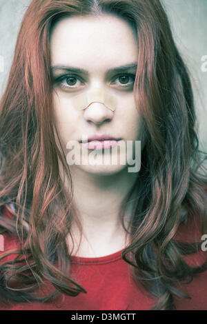 Portrait of a young woman with a band-aid on her nose Stock Photo