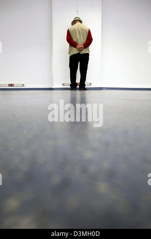 An elderly man faces a wall at the city library in Frankfurt,  Germany, Wednesday, 15 March 2006. The man takes part as an extra of the art initiative 'The Punished' by Spanish artist Santiago Sierra, which includes elderly people standing in front of walls at nine different locations around the city as symbolic gestures of humility. Sierra attracted attention in Pulheim near Colog Stock Photo