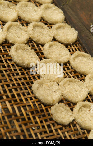 Sticky rice cakes drying on a bamboo rack in the sun Stock Photo
