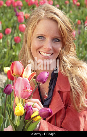 Dutch woman between the flower fields in the Netherlands Stock Photo