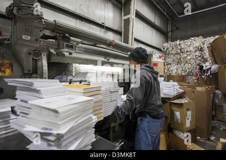 Royal Oak, Michigan - A worker cuts the covers off books so they can be recycled at Royal Oak Recycling. Stock Photo
