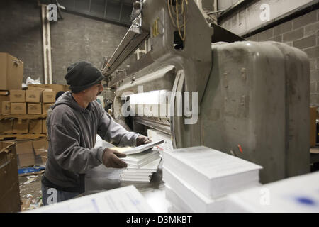 Royal Oak, Michigan - A worker cuts the covers off books so they can be recycled at Royal Oak Recycling. Stock Photo