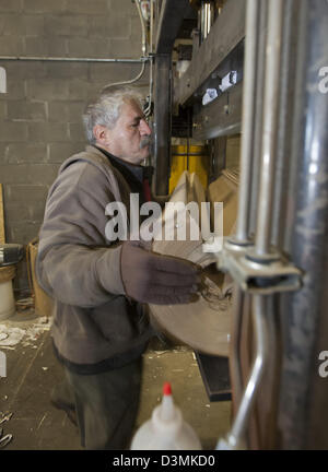 Royal Oak, Michigan - A worker cuts a roll of paper so it can be recycled at Royal Oak Recycling. Stock Photo