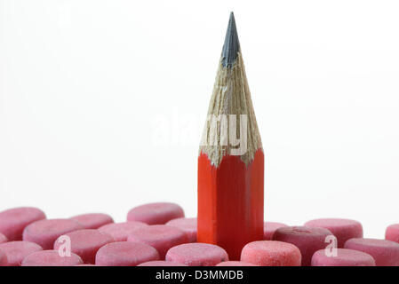 Sharp red pencil against a white background with out of focus erasers Stock Photo