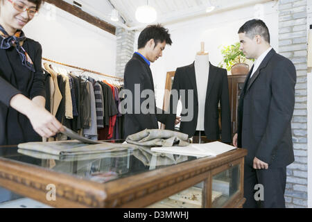 Customer and Business Owner discussing suit jacket in a bespoke boutique in Beijing, China Stock Photo