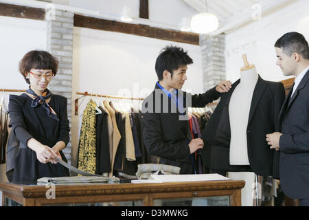 Customer and Business Owner discussing suit jacket in a bespoke boutique in Beijing, China Stock Photo