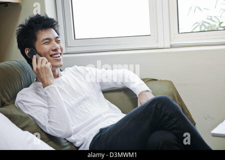Happy Young Chinese Man in Mobile Phone Call Conversation Stock Photo