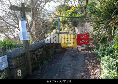 Traffic signs warning of a footpath and road closure due to an unstable cliff and rockfall in Kingswear, Devon Stock Photo