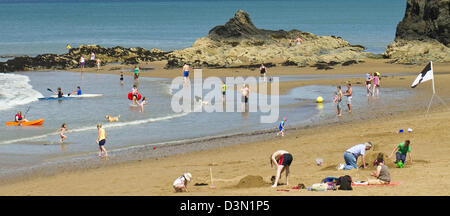 People holiday makers enjoying hot summers day on beach at Aberporth in Ceredigion Wales Stock Photo