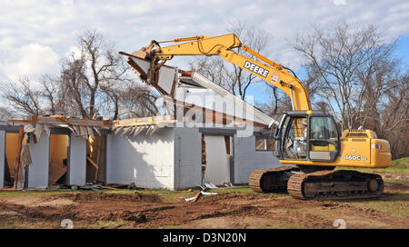 A wrecker tears down the bathrooms at a football stadium in Madison CT USA as the town prepares to build a new one. Stock Photo