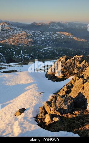 View towards Langdale Pikes from Wetherlam at dusk in winter in the English lake District Stock Photo